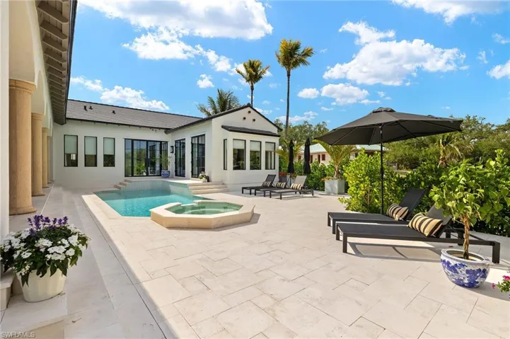 Pool with a patio area and an in ground hot tub