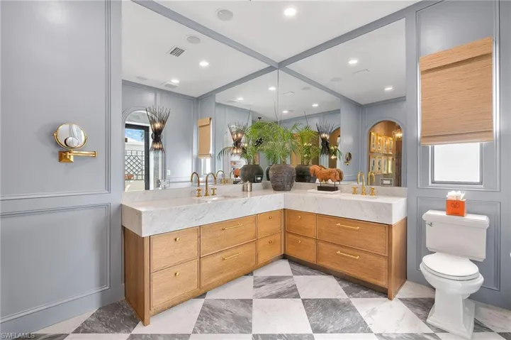 Bathroom with toilet, double vanity, and visible vents