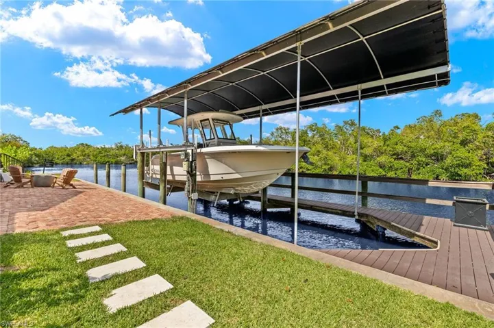 Dock area featuring a yard, a water view, and boat lift