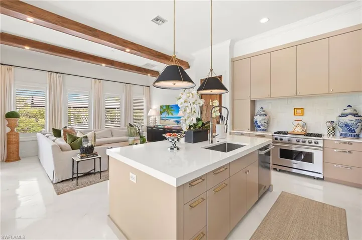 Kitchen featuring cream cabinets, appliances with stainless steel finishes, a sink, visible vents, and open floor plan