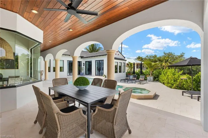 View of patio / terrace with outdoor dining area, a ceiling fan, and an in ground hot tub