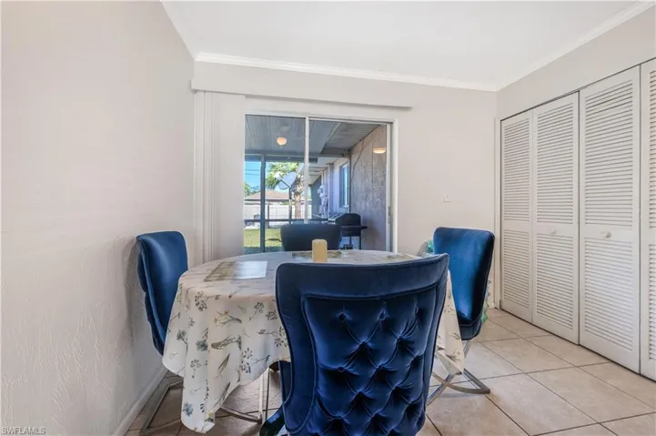 Dining space with tile patterned floors and ornamental molding