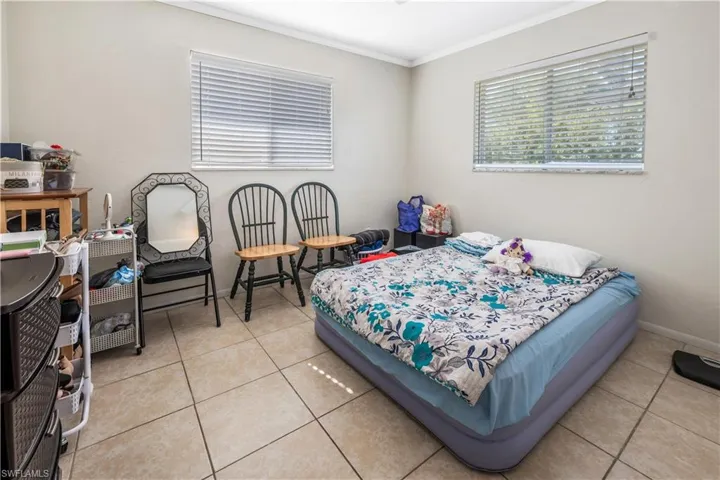 Bedroom featuring crown molding and light tile patterned floors