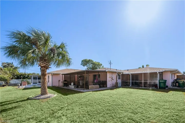 Rear view of property with a sunroom and a yard