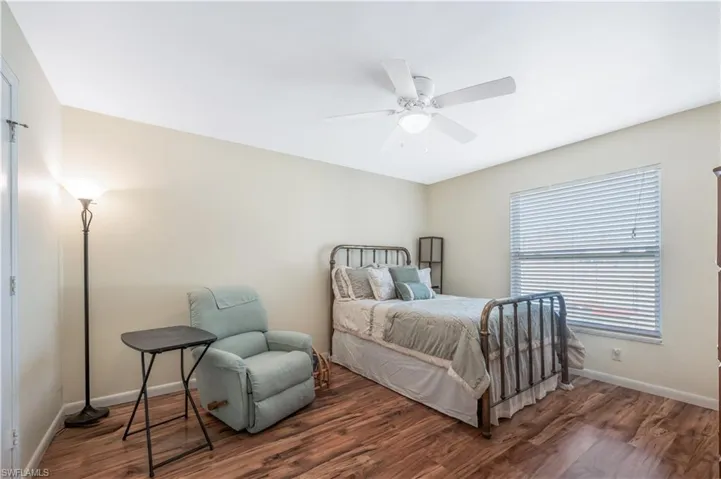 Bedroom with ceiling fan and dark wood-type flooring