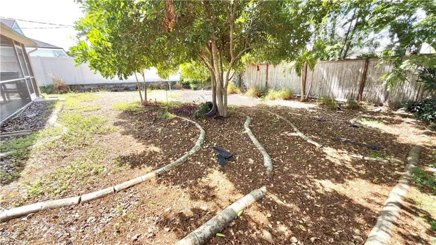 Expansive backyard featuring mature trees, wood-finish border elements