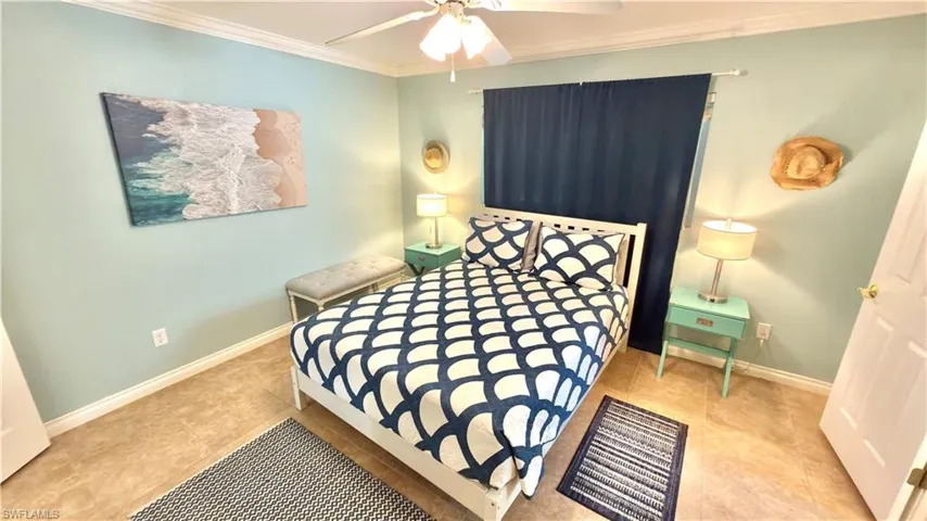 Light blue painted walls with crown molding, ceiling fan, and tile flooring.
