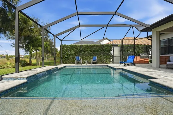 Swimming pool featuring a sunroom, glass enclosure, a grill, and a patio area