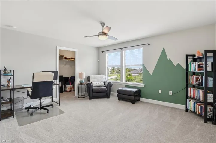 Office space with light carpet and a ceiling fan
