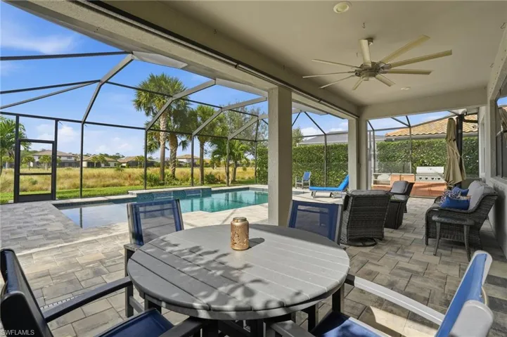 View of patio / terrace with ceiling fan, a sunroom, glass enclosure, outdoor dining area, and an outdoor pool