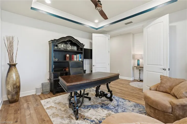 Office featuring light wood-type flooring, recessed lighting, a raised ceiling, and ceiling fan