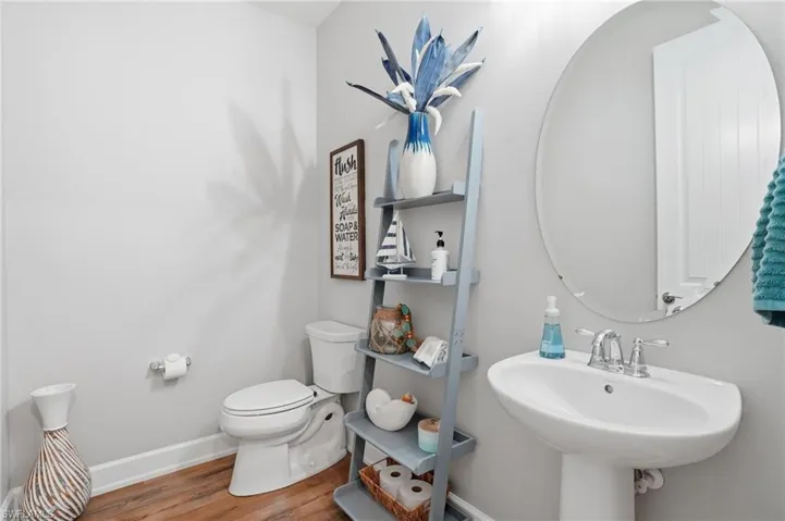 Half bath featuring baseboards and wood finished floors