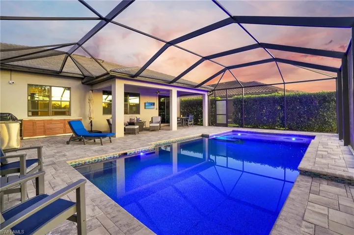 Swimming pool featuring a sunroom, glass enclosure, a patio area, and outdoor lounge area