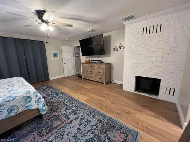 Primary Bedroom Fireplace and sliding glass impact door to Lanai
