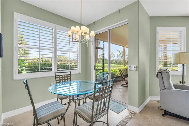 Tiled dining area featuring a wealth of natural light and a notable chandelier