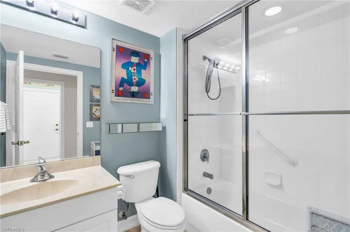 Full bathroom featuring vanity, combined bath / shower with glass door, and toilet