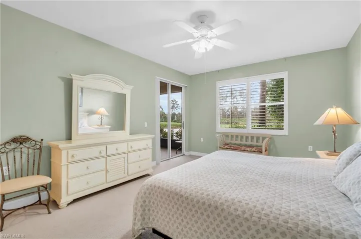 Carpeted bedroom featuring ceiling fan and access to exterior