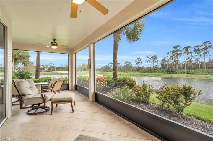 Sunroom with ceiling fan and a water view