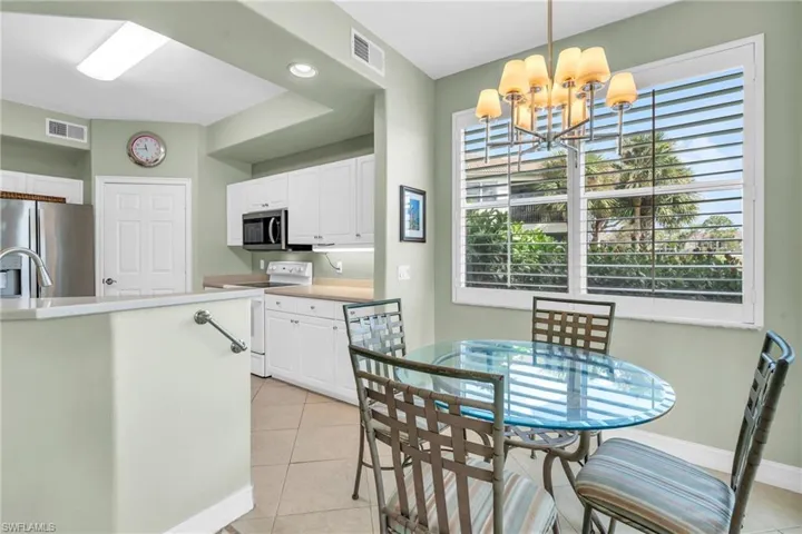 Tiled dining room with a chandelier and sink