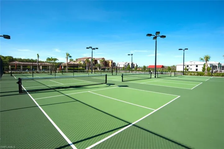 Multiple outdoor courts featuring a green playing surface and white line markings