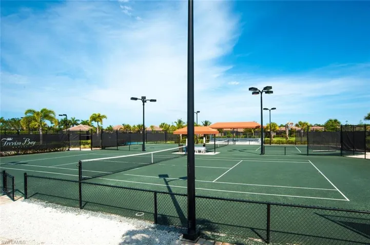 Multiple tennis courts featuring green surfacing and white court lines