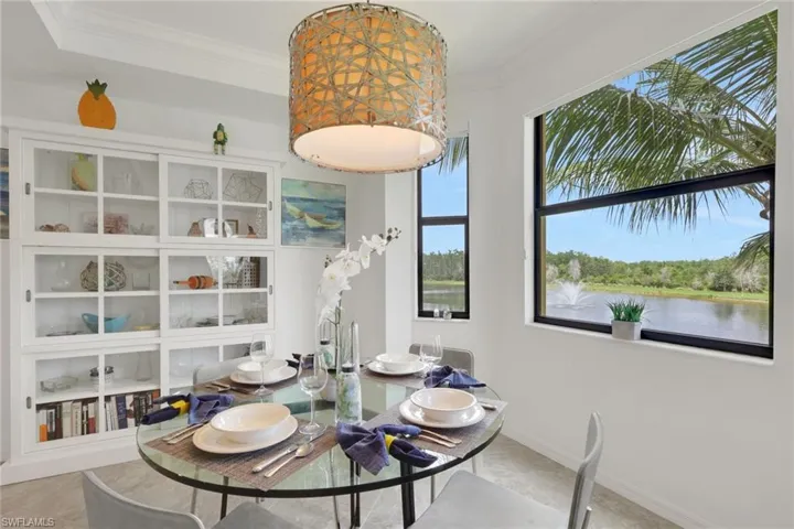 Dining area featuring a contemporary glass-top dining table, a woven drum pendant light fixture, and built-in white cabinetry with glass-front doors
