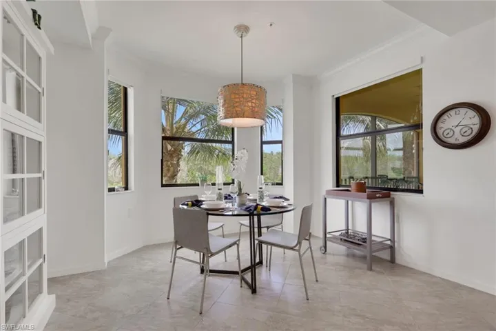 Dining area featuring multiple windows, tiled flooring, and crown molding