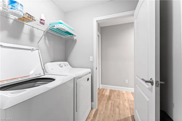 Laundry area with light hardwood / wood-style floors and washing machine and dryer