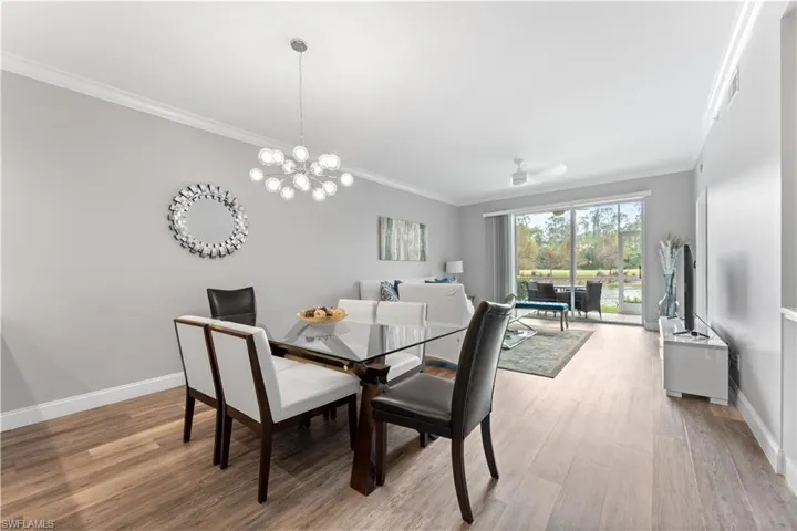 Dining room featuring light hardwood / wood-style floors, a notable chandelier, and ornamental molding