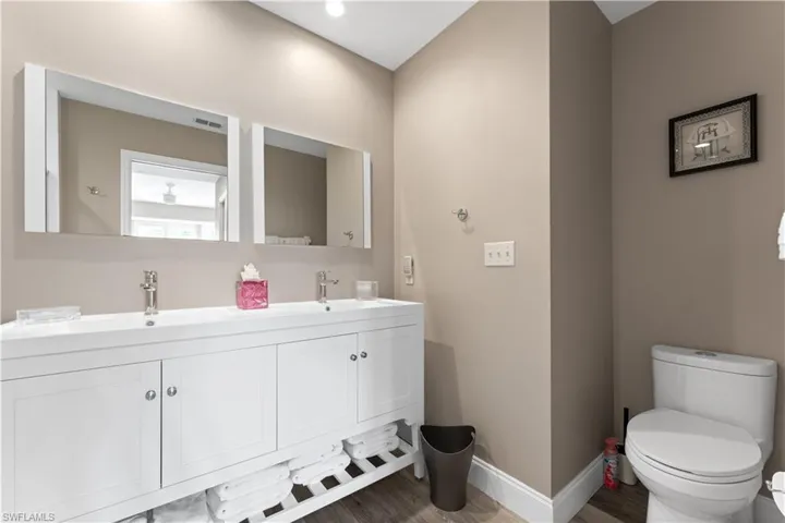 Bathroom featuring vanity, wood-type flooring, and toilet
