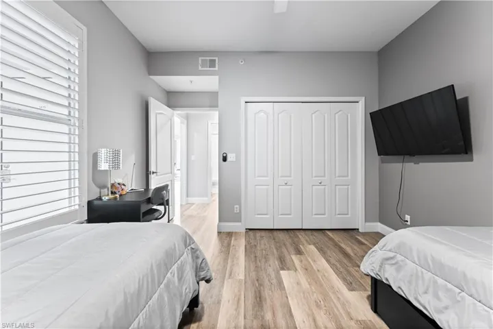 Bedroom with ceiling fan, light wood-type flooring, and a closet