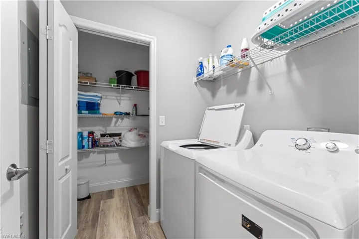 Laundry room featuring light wood-type flooring and washing machine and clothes dryer
