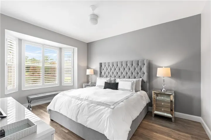 Bedroom with ceiling fan and dark wood-type flooring