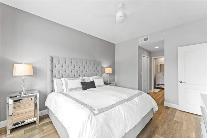 Bedroom with hardwood / wood-style floors, a closet, ensuite bath, and ceiling fan