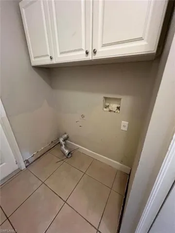 Laundry room featuring light tile patterned flooring, washer hookup, and cabinet space