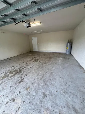 Garage featuring water heater and a garage door opener