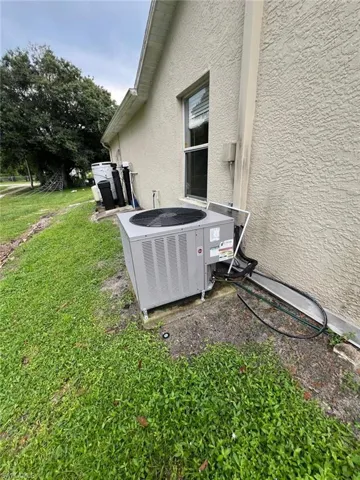 Exterior view of stucco siding and a cooling unit