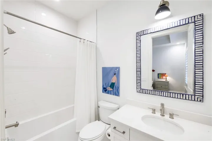 Bathroom featuring vanity and shower / bath combination with curtain