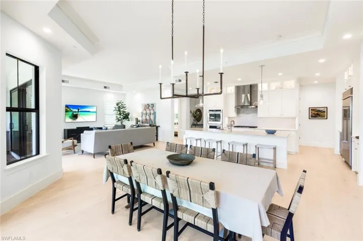 Dining space with recessed lighting, light wood-style floors, and a tray ceiling