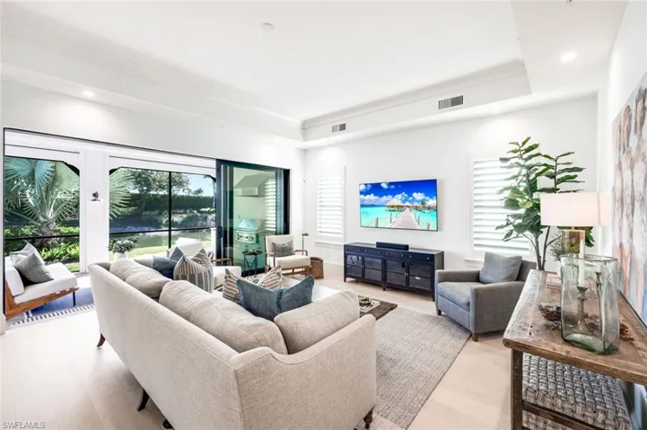Living room featuring light wood-type flooring, recessed lighting, and a raised ceiling