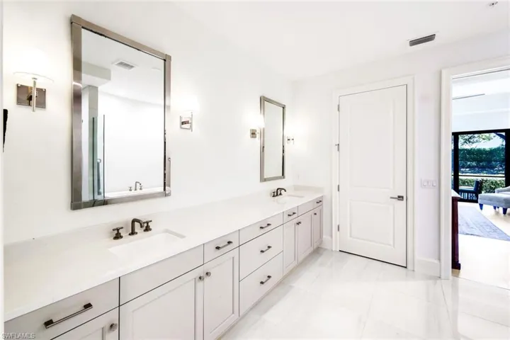 Bathroom featuring double vanity and light tile patterned flooring