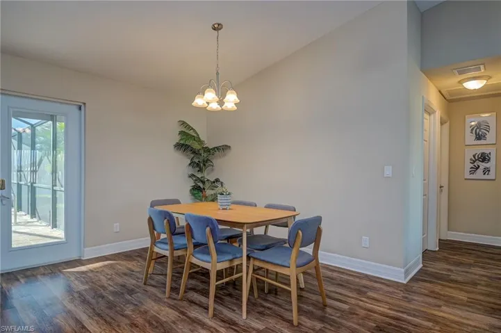 Dining room featuring a chandelier, high vaulted ceiling, and dark hardwood / wood-style flooring