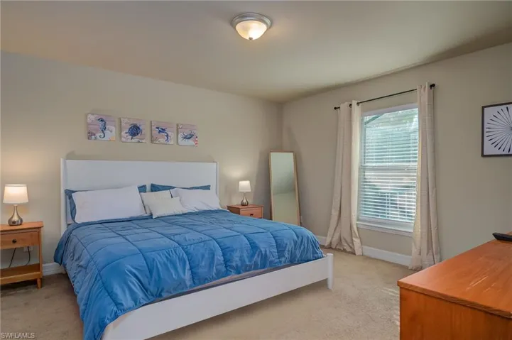 Carpeted bedroom featuring multiple windows