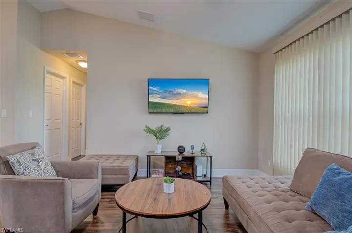Living room with hardwood / wood-style flooring and lofted ceiling