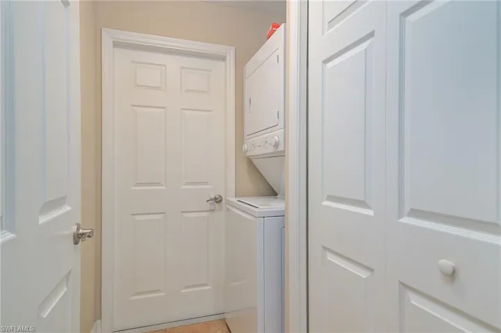 Laundry area with stacked washer and clothes dryer