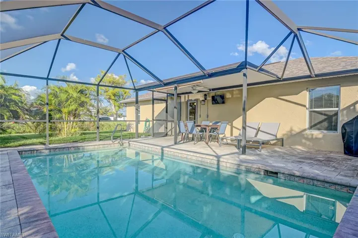 View of swimming pool with ceiling fan, a lanai, and a patio