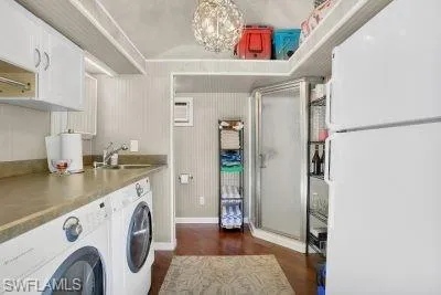 Laundry area with dark wood-style floors, a chandelier, and separate washer and dryer
