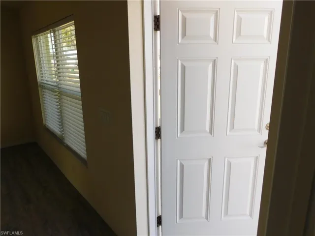 Corridor with dark wood finished floors and baseboards