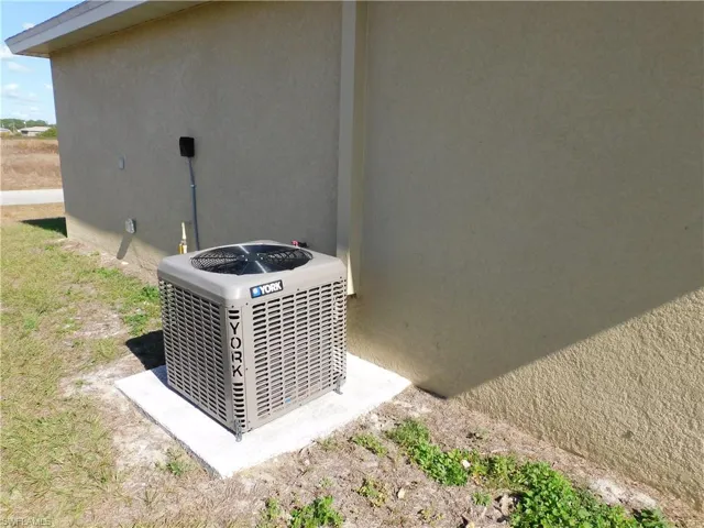 Exterior view of stucco siding and a cooling unit