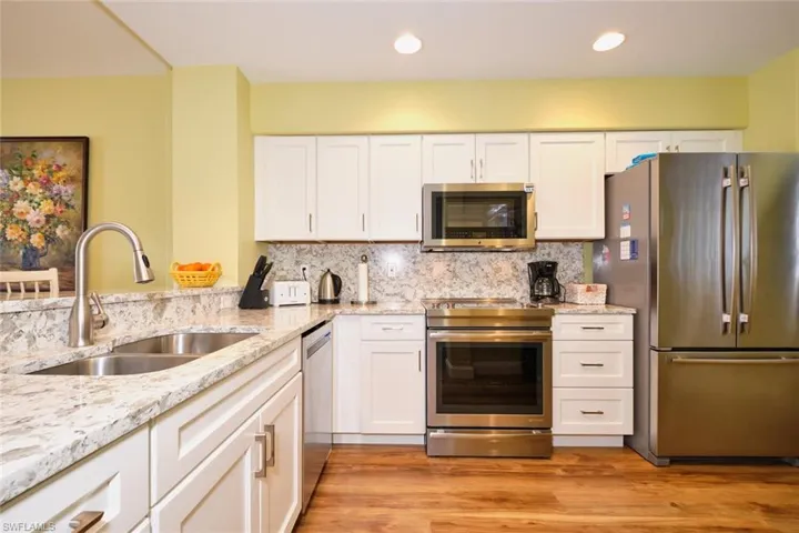 Kitchen with white cabinets, a sink, and stainless steel appliances